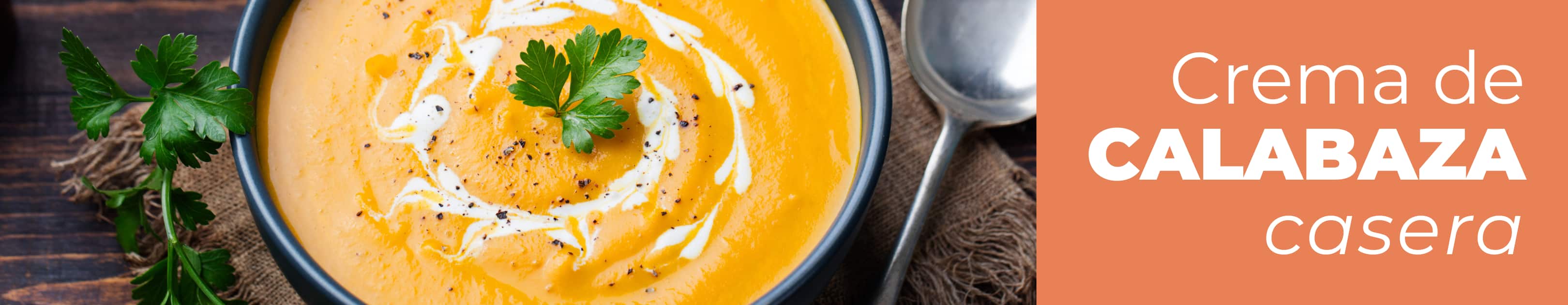 Plato hondo de cerámica con crema de calabaza terminada y humeante, decorada con unas semillas y un hilito de aceite de oliva.